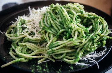 Spaghetti with green arugula sauce of garlic and olive oil, with grated cheese. 