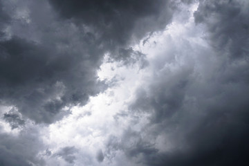 Dark, grim, stormy, rainy sky with rays of light. Scary hurricane clouds. Natural element. Stock Photo for your design