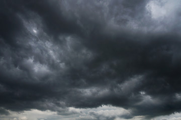 Dark, grim, stormy, rainy sky with rays of light. Scary hurricane clouds. Natural element. Stock Photo for your design