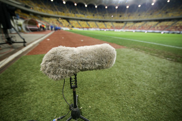 Hairy boom microphone on the grass of a soccer stadium