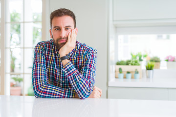 Handsome man wearing colorful shirt thinking looking tired and bored with depression problems with crossed arms.