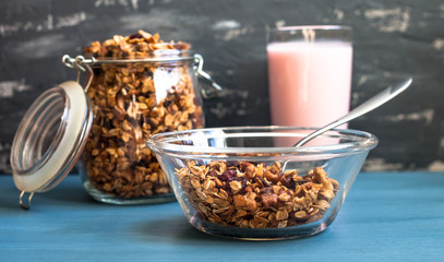 Homemade muesli with yogurt in a plate on a blue background, healthy breakfast of oatmeal muesli, nuts, seeds and dried fruits