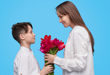 Little boy giving bouquet to mother 