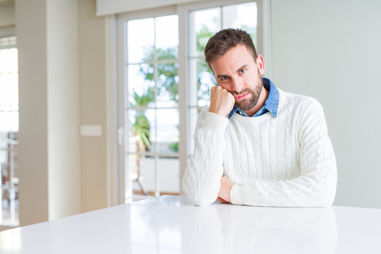 Handsome man wearing casual sweater thinking looking tired and bored with depression problems with crossed arms.