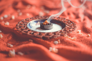 Frankincense burning on a hot coal. Frankincense is an aromatic resin, used for religious rites, incense and perfumes, incense smoke