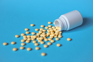 Assorted pharmaceutical medicine pills, tablets and capsules and bottle on blue background. Drugs and various narcotic substances. Copy space for text. Stock photo for design