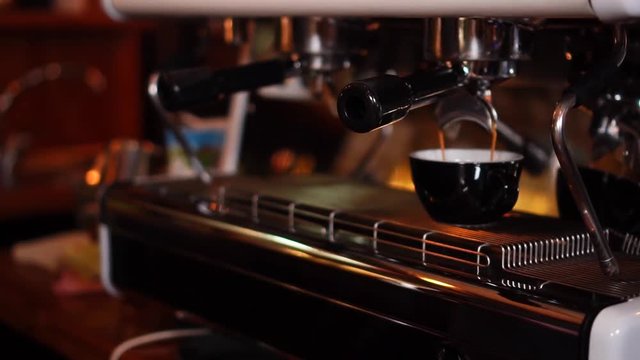 Slow motion close up view on high technology coffee machine making espresso in small cappuccino cup