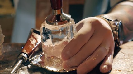 Barman is making brand ice for the cocktail at bar