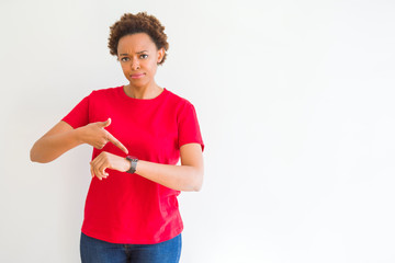 Young beautiful african american woman over white background In hurry pointing to watch time,...