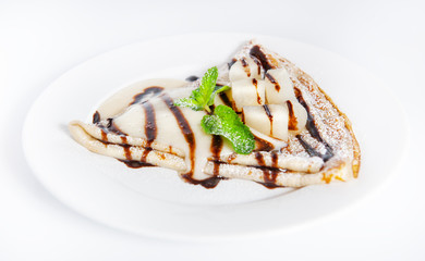 Thin delicious pancake with condensed milk on white