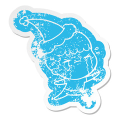 cartoon distressed sticker of a man crying wearing santa hat