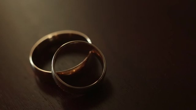 Gold engagement rings on beige background. Wedding Rings. Two splendid wedding rings on a wedding day. Two wedding rings on the table