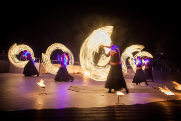Amazing fire show dance. Fire dancers in beautiful costumes playing with colorful flames