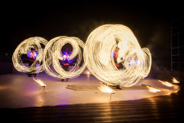 Amazing fire show dance. Fire dancers in beautiful costumes playing with flame