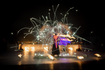 Amazing fire show dance. Fire dancers in beautiful costumes playing with flame