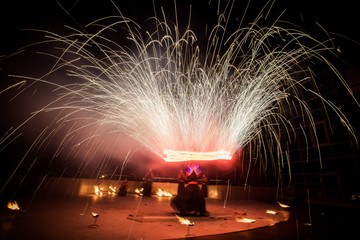 Amazing fire show dance. Fire dancers in beautiful costumes playing with colorful flames