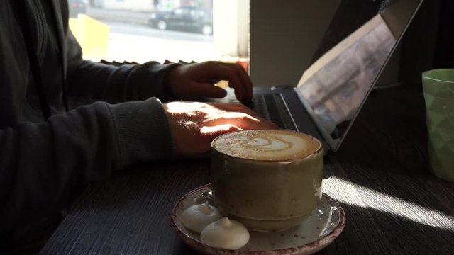 Digital technology, software development concept. Close-up hands - software developer (programmer) typing code for mobile device. Business office concept with cup of coffee and wooden table. Freelance