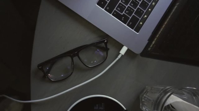 Digital technology, software development concept. Top view of close-up cup glasses, smartphone, keyboard and hands on wooden table - software developer (programmer) typing code for mobile device. Busi