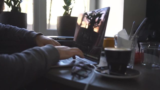 Digital technology, software development concept. Close-up hands - software developer (programmer) typing code for mobile device. Business office concept with cup of coffee and wooden table. Freelance