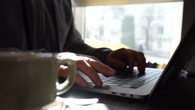 Untitled Digital technology, software development concept. Close-up hands - software developer (programmer) typing code for mobile device. Business office concept with cup of coffee and wooden table. 