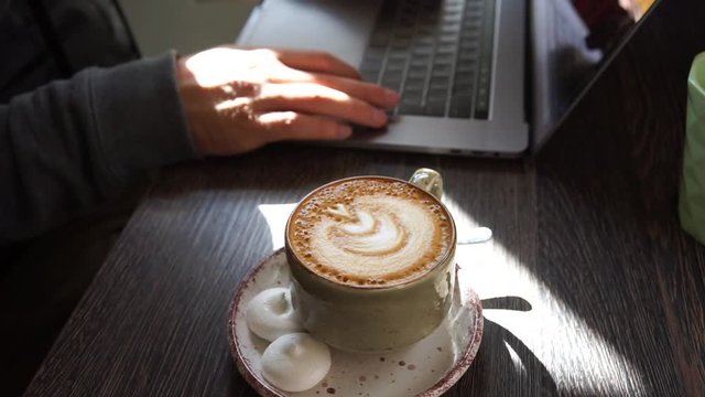 Digital technology, software development concept. Close-up hands - software developer (programmer) typing code for mobile device. Business office concept with cup of coffee and wooden table. Freelance