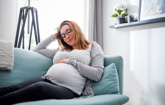Pregnant woman relaxing at home on the couch