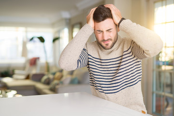 Young handsome man at home suffering from headache desperate and stressed because pain and...