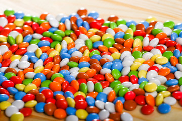 Fototapeta na wymiar colorful chocolate candies on wooden background