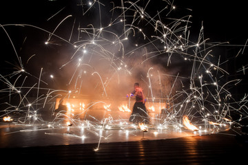Amazing fire show dance. Fire dancers in beautiful costumes playing with colorful flames