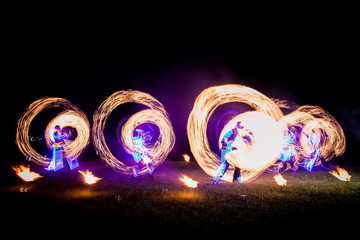Amazing fire show dance. Fire dancers in beautiful costumes playing with flame