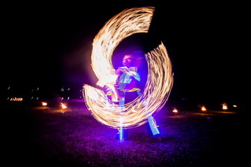 Amazing fire show dance. Fire dancers in beautiful costumes playing with colorful flames