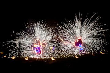 Amazing fire show dance. Fire dancers in beautiful costumes playing with colorful flames