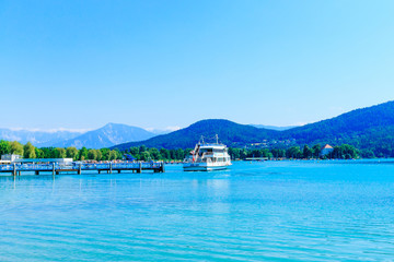 Summer view of the lake and mountain. pier and cruising boat