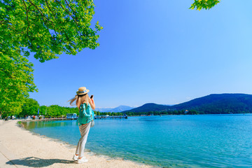 girl with a backpack and a boater on the shore of a lake. the gi