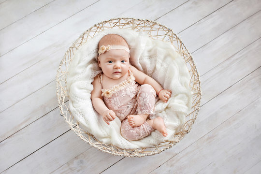 Little newborn baby girl  1 month lying in a wattled basket. Copy space