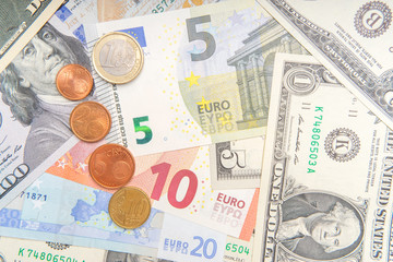 group of coins on background of various Euro and Dollar banknotes