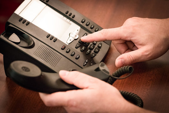 Finger dialing phone call on touch tone telephone.