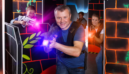 Obraz premium Portrait of glad man with laser gun having fun
