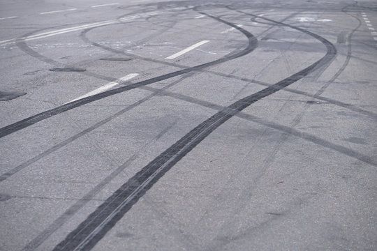 Abstract of Black tire wheels caused by Drift car on the road. Braking at a pedestrian crossing and a road with markings. Stock photo for design