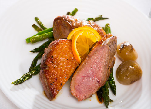 Roasted duck breast with asparagus closeup