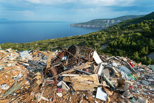 Piles of waste at landfill next to sea. Waste management, ecology, enviromental issues concept