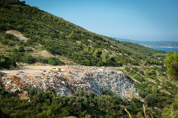Piles of waste at landfill next to sea. Waste management, ecology, enviromental issues concept