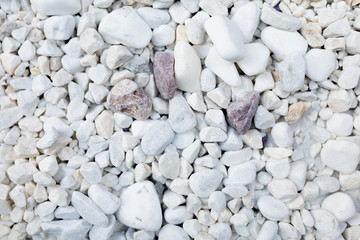 White pebbles stone texture background in different size view from above, closeup.
