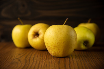 Yellow apple on the wooden vintage background