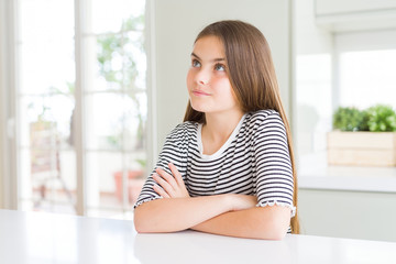 Beautiful young girl kid wearing stripes t-shirt smiling looking side and staring away thinking.