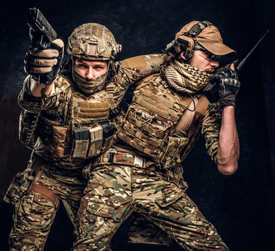 Combat conflict, special mission. The military soldier carrying teammate out of the battlefield. Studio photo against a dark textured wall