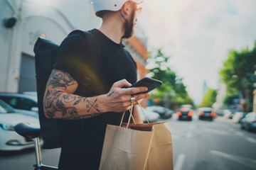 Courier delivery food service at home. Man courier using a map app on mobile phone to find the delivery address in the city.