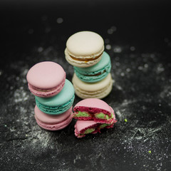 colored macaroons on a black background