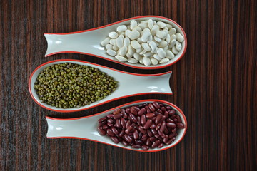 different types of beans in spoons