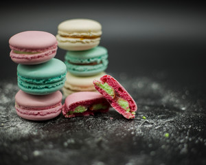 colored macaroons on a black background